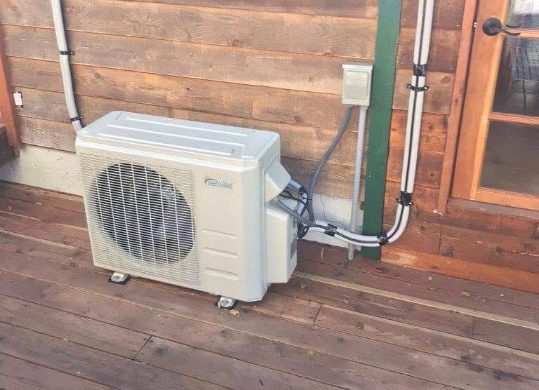 Ductless mini-split heat pump installed on exterior of house